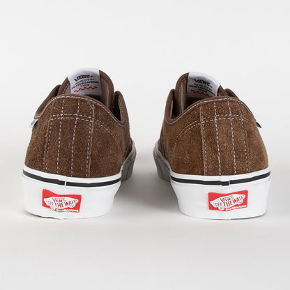 A pair of Vans platform sneakers shown from the back, featuring a brown suede upper, white platform soles, and the signature red Vans logo patch on the heel.