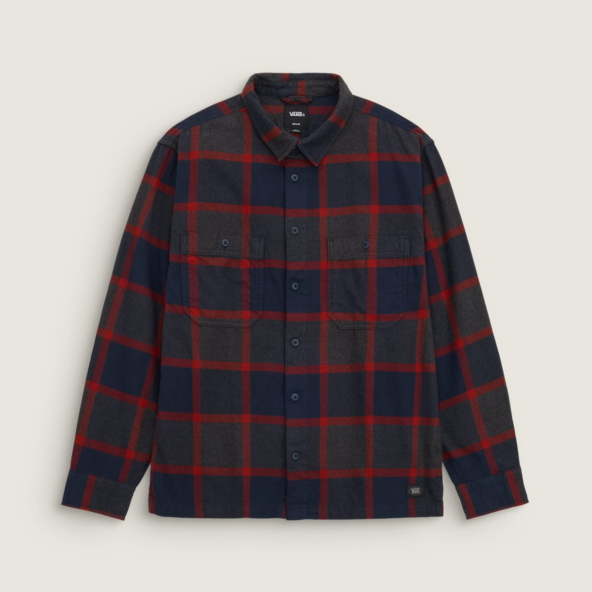 A long-sleeve button-up flannel shirt by Uniqlo's Vessas collection, featuring a dark navy and charcoal gray plaid pattern with red accent lines, displayed flat against a light beige background.