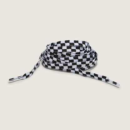 Black and white checkered shoelace on a beige background