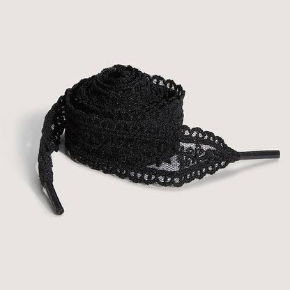 Black lace shoelaces on a light gray background