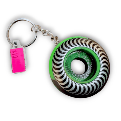 Keychain with a black and white striped design and green center on a white background