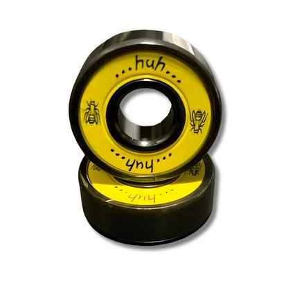 Two yellow skateboard bearings with text on a white background