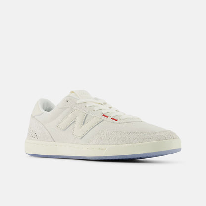 White sneaker with red label on a light gray background