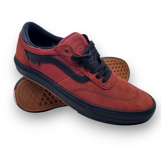 Red sneaker with black laces and sole on a white background