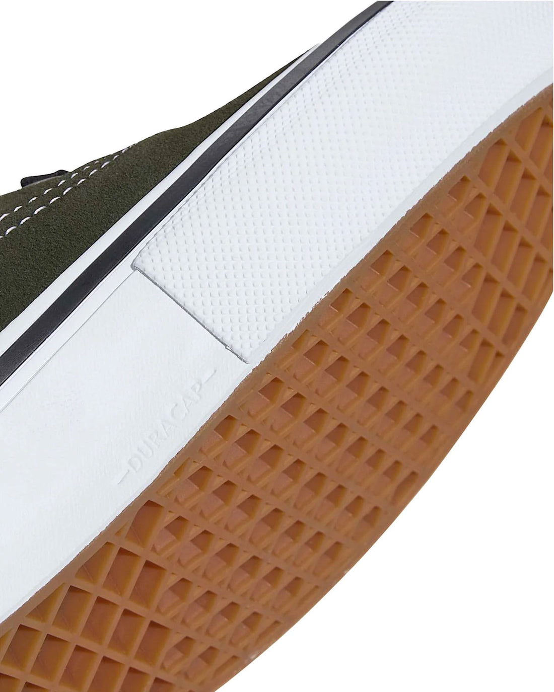 Close-up of a low-top sneaker showing the dark olive green suede upper, white midsole, black stripe, and brown gum outsole.