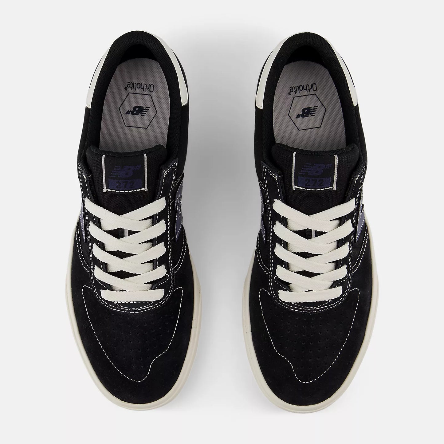 Black sneakers with white laces on a light gray background