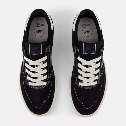 Black sneakers with white laces on a light gray background