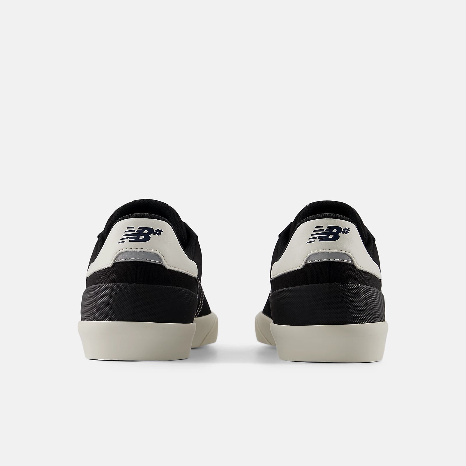 Black and white sneakers with New Balance logo on a light gray background