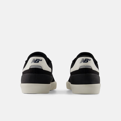 Black and white sneakers with New Balance logo on a light gray background