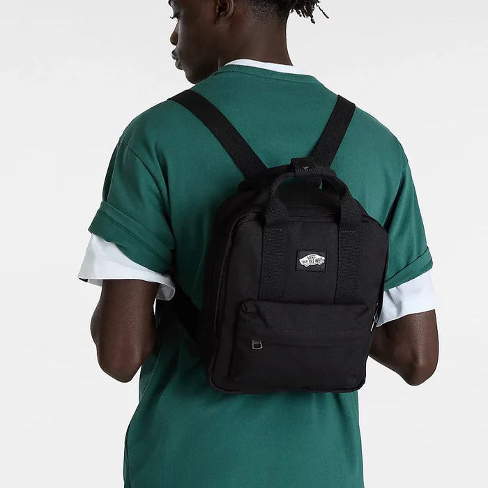Person wearing a black backpack with a visible brand logo on a white background
